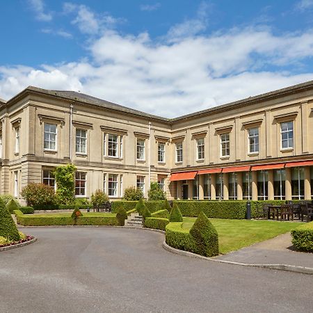 Macdonald Bath Spa Hotel Exterior foto The photo depicts a large, elegant building with a classic architectural style, featuring a combination of stone and large windows. The structure appears to have two sections: a main, stately part on the left and an adjoining section that has a terra