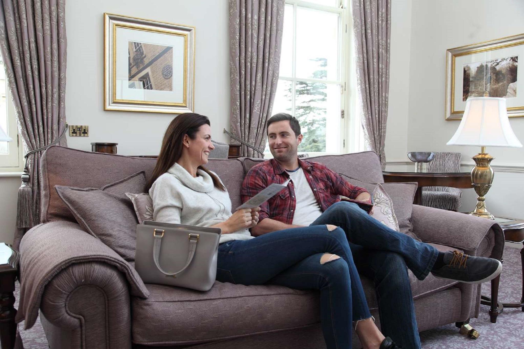 Macdonald Bath Spa Hotel Exterior foto The photo shows a man and a woman sitting together on a comfortable sofa in a well-decorated room. The woman is holding a piece of paper and appears to be engaged in conversation with the man, who is smiling in response. They are both dressed casuall