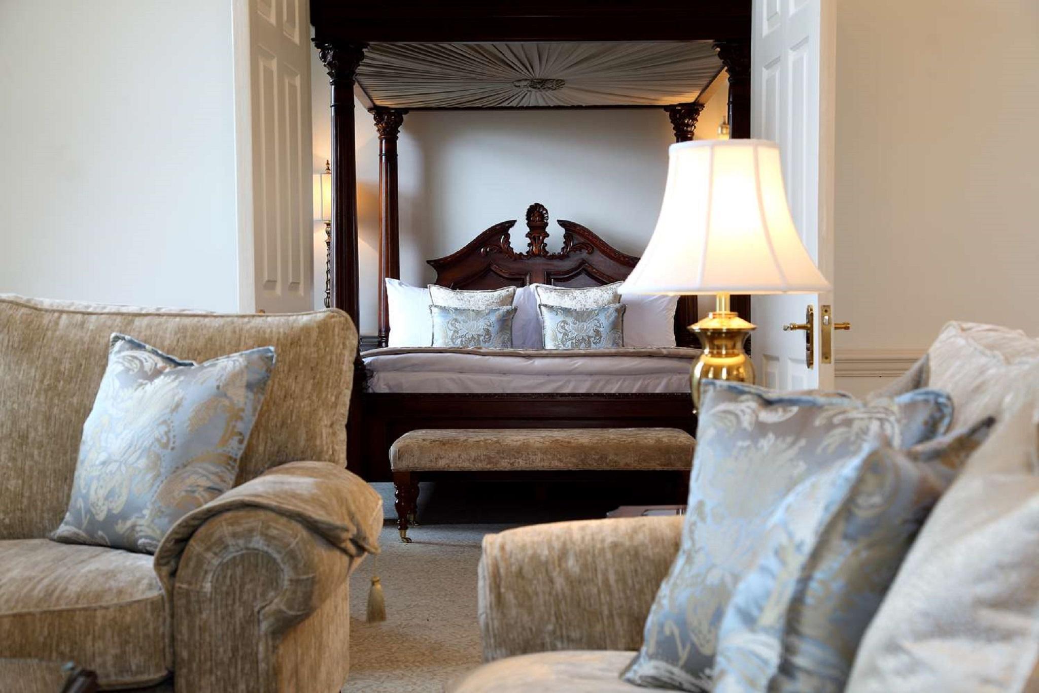 Macdonald Bath Spa Hotel Exterior foto The photo shows a beautifully decorated room featuring a four-poster bed in the background. The bed has a wooden frame with a rich design, and it is adorned with plush bedding and pillows. In the foreground, there are comfortable sofas with decorativ