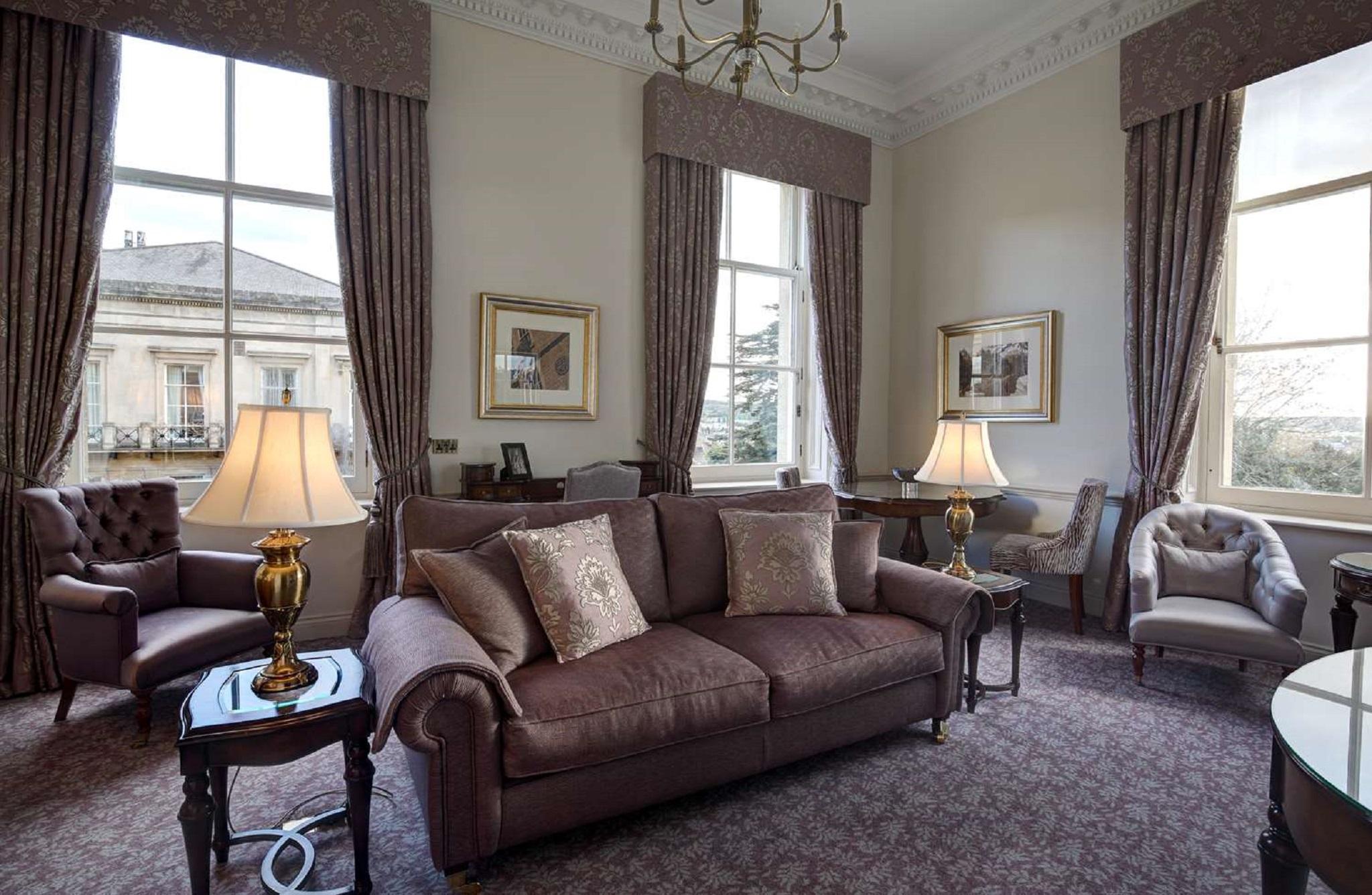 Macdonald Bath Spa Hotel Exterior foto The photo shows a well-furnished living room with an elegant and cozy atmosphere. There is a brown couch with decorative pillows in the center. Two armchairs are positioned next to it, with a small table in the middle. The room features large windows