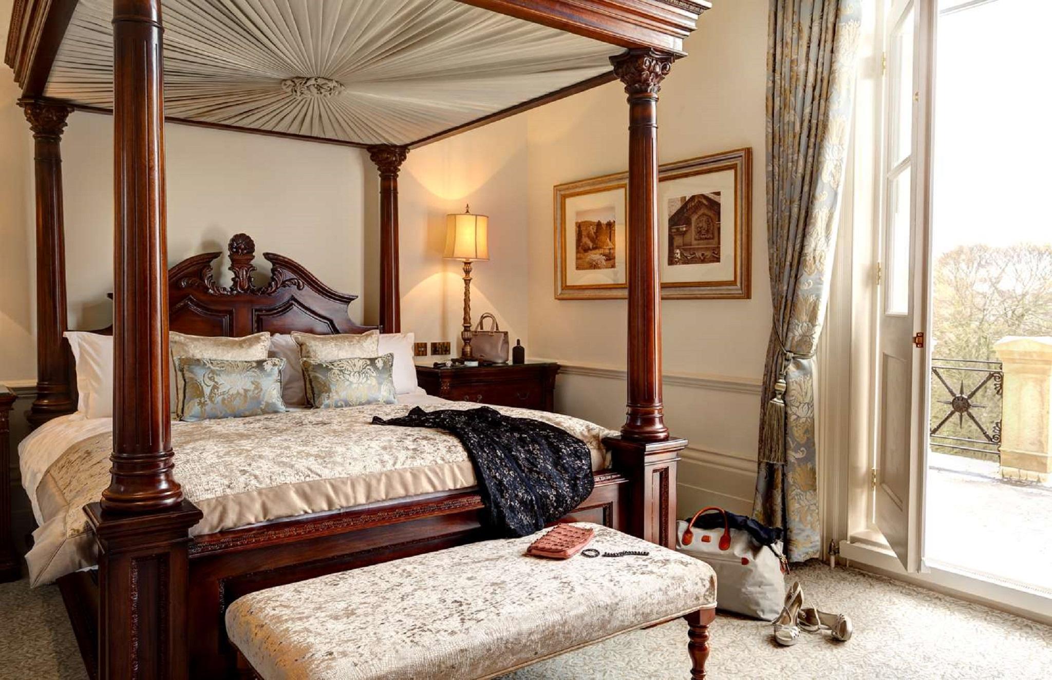 Macdonald Bath Spa Hotel Exterior foto The photo depicts a beautifully designed bedroom featuring a four-poster bed with a decorative canopy. The bed is dressed with elegant bedding and several patterned pillows. Adjacent to the bed, there is a matching wooden nightstand with a stylish la