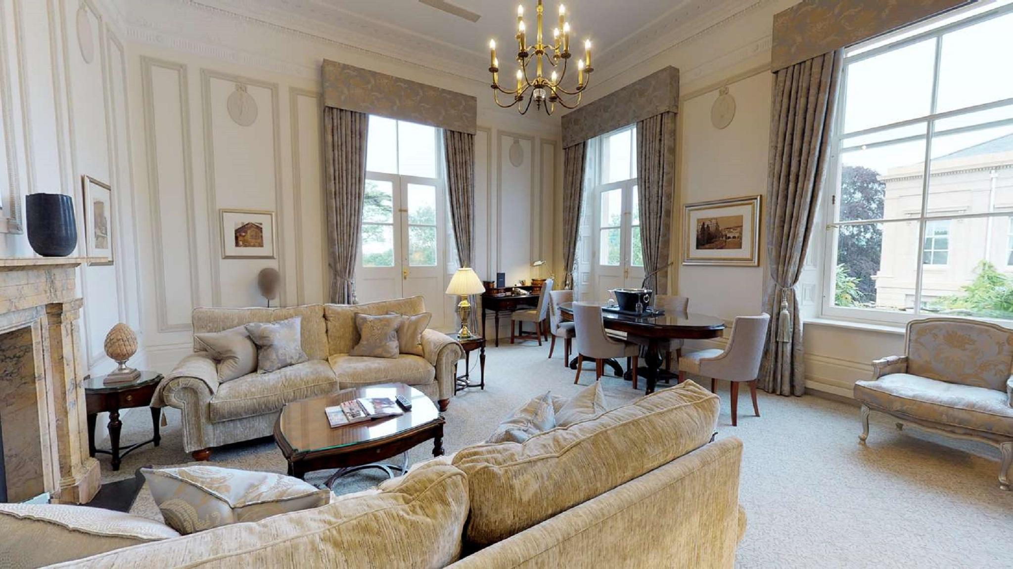 Macdonald Bath Spa Hotel Exterior foto The photo displays a spacious and elegantly furnished living room. It features plush sofas and armchairs arranged around a central coffee table, creating a cozy seating area. Large windows adorned with long curtains allow natural light to fill the ro