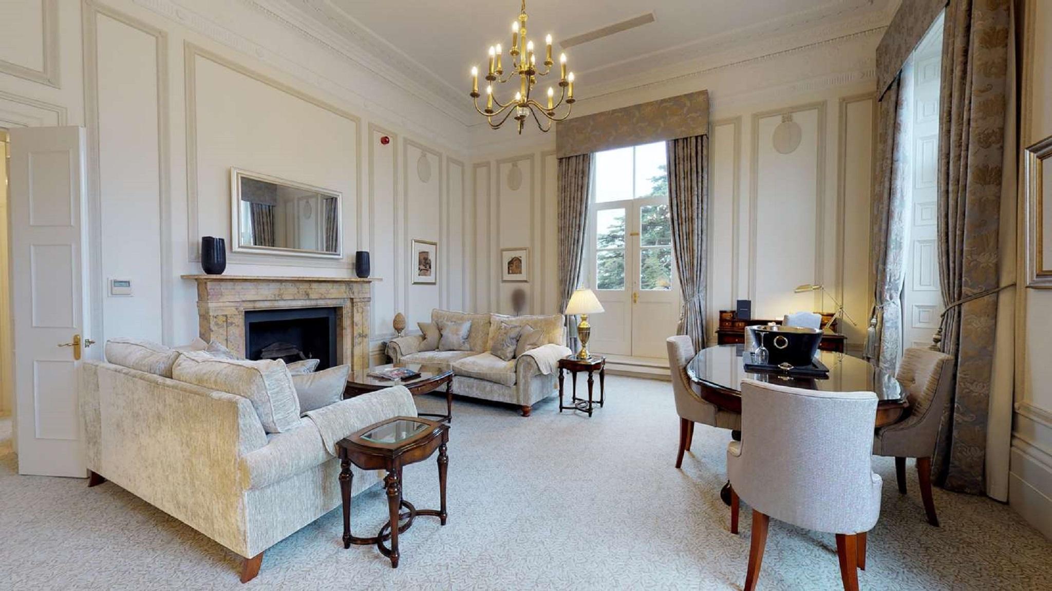 Macdonald Bath Spa Hotel Exterior foto The photo shows an elegant living room with a classic design. It features a large chandelier hanging from the ceiling, providing soft lighting. The walls are adorned with decorative moldings and have a light color. 

In the center, there are two plus