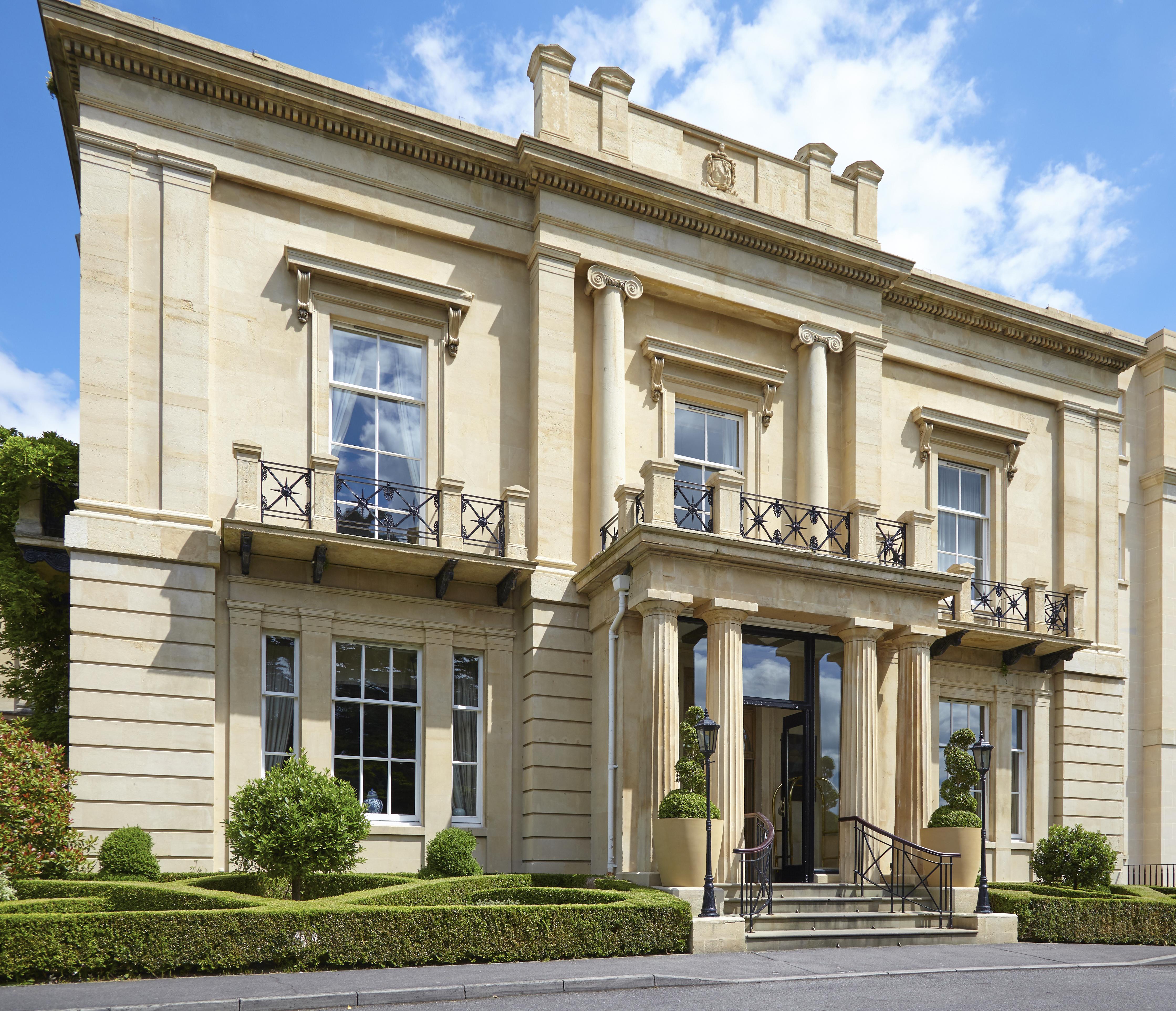 Macdonald Bath Spa Hotel Exterior foto The photo shows a large, elegant building designed in a classical architectural style. It features a symmetrical facade with tall columns and decorative details. The entrance is marked by a set of stairs leading up to double doors, flanked by windows